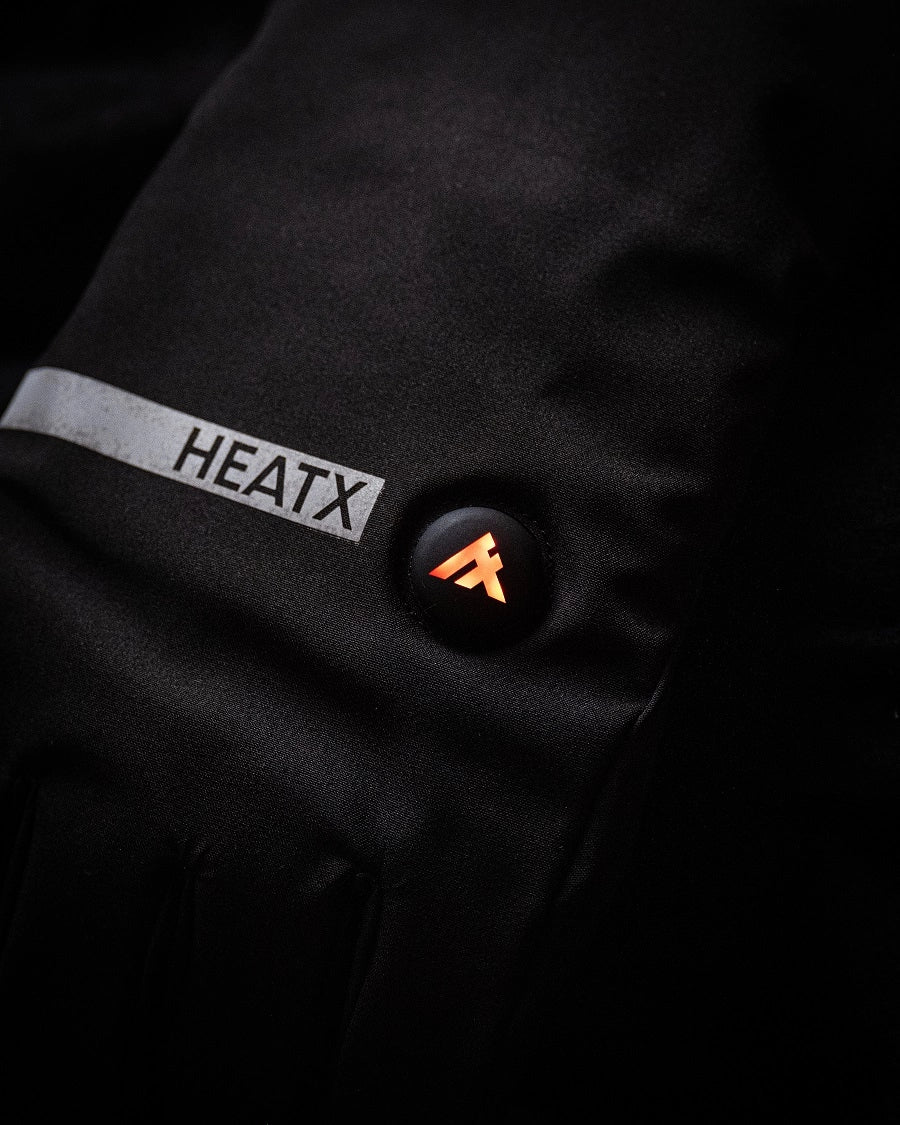 Knappen på en HeatX-värmehandske lyser orange i mörkret