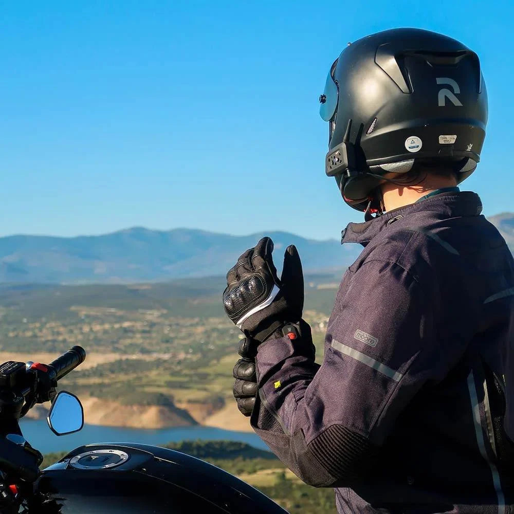 En motorcyklist i Savior Heats värmehandskar med utsikt över bergen