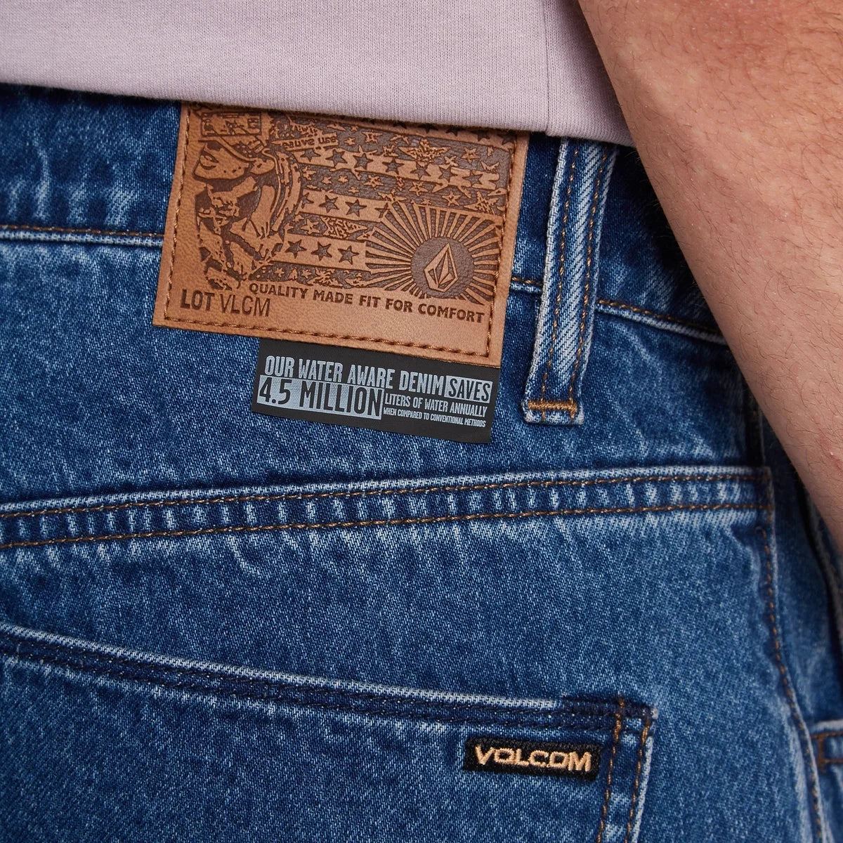 Närbild på bakfickan och Volcom-märket på ett par blå Billow-jeans
